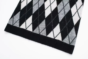 Detail of classic black and grey argyle pattern knit dress with ribbed cuff texture