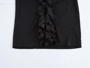Detailed close-up of 3D 3D-petal floral decorations on elegant black long sleeve blouse