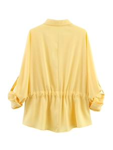 Detail of yellow long sleeve shirt back with elastic waist and silky drape texture