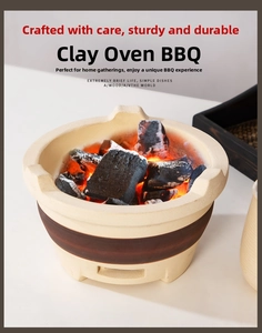 Close-up of portable ceramic stove with glowing charcoal embers on a wooden tray