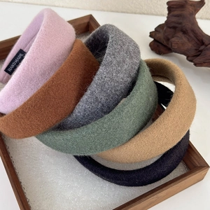 Elegant wide wool fabric headbands in a set of six various colors on a wooden tray