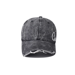 Detailed close-up of vintage washed black denim baseball cap with white embroidery