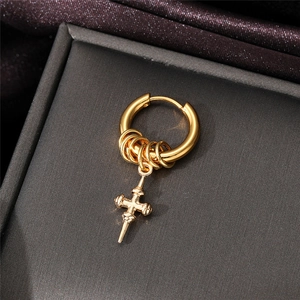 Macro shot of a golden stainless steel cross pendant earring in a jewelry box