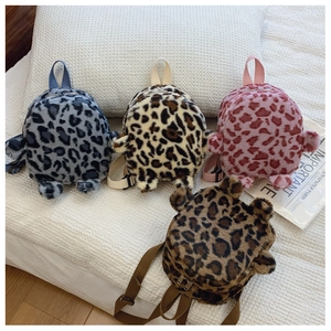 Detail of plush leopard print mini backpacks in blue, beige, pink and dark brown colors