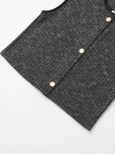 Dettaglio del gilet in tweed grigio con tessuto strutturato ed eleganti bottoni dorati