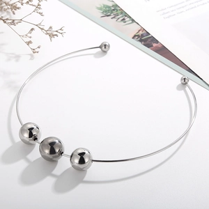 Minimalist silver metal collar featuring three large polished beads on a sleek wire frame