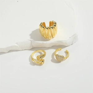 Three-piece gold heart ring set with zircons and textured metal on a marble display