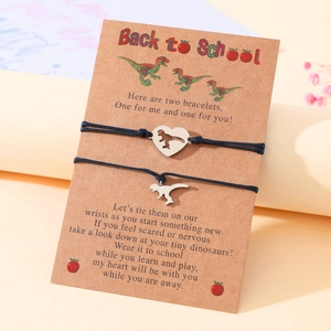 Macro shot of stainless steel dinosaur bracelets on a Back to School message card