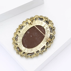 Detail view of the vintage gold-tone brooch back with secure safety pin clasp
