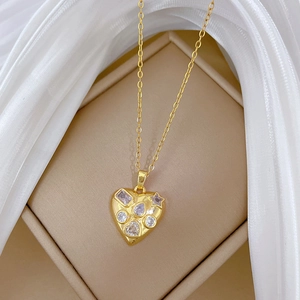 Gold heart necklace with multi-shaped crystals on a jewelry box with white tulle