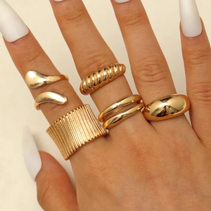 Detail von 5-teiligem Goldring-Set mit geschmolzener Lava und offenen Strukturen