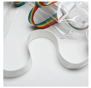 Detail of transparent PVC tote bag featuring rainbow striped and white nylon shoulder straps