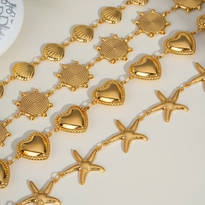 Macro detail of golden charms featuring sea stars, hearts, sun discs and sea shells