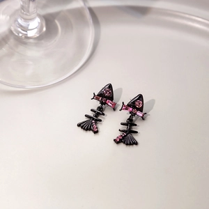 Detail of fishbone earrings featuring black metal finish and sparkling pink zircon stones