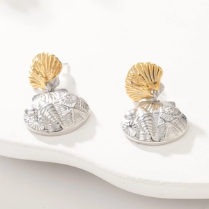 Detail of silver embossed starfish and golden scallop shell charms on wave stand