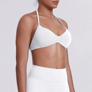 Detailed side view of white ribbed sports bra with halter straps and ruched chest design