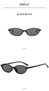 Detail view of retro oval sunglasses with glossy black frames and dark grey lenses