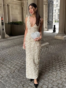 Robe longue élégante blanc crème à col en V avec texture florale 3D en décor urbain