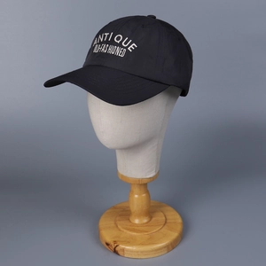 Detail of black nylon baseball cap with white Antique Old-Fashioned embroidery text