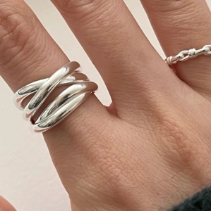 Nahaufnahme eines minimalistischen 925 Sterling Silber Mehrschicht-Kreuzrings am Finger