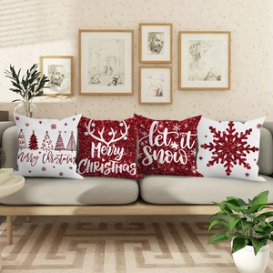 Detailed view of four red glitter Christmas pillow covers with snowflakes and deer on a sofa