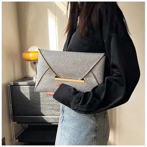 Détail de la pochette enveloppe argentée scintillante avec bordure et boucle en métal doré