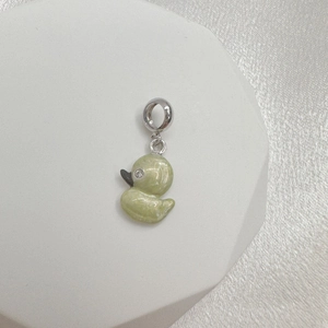 Detail of light green enamel duck charm with silver loop and sparkling crystal eye