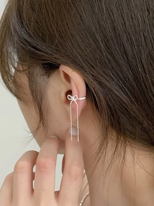 Detailed view of silver bow zircon tassel ear clip on model without ear piercing