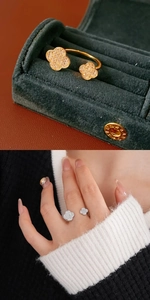 Detail of clover open rings with cubic zirconia on velvet box and model's hand