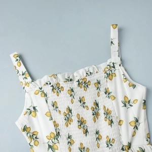 Detail of floral summer dress featuring lemon print smocking and ruffled neckline edges