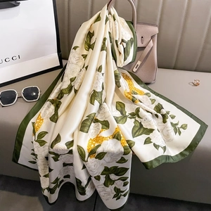 Elegant camellia print silk scarf with golden chain patterns and deep green borders