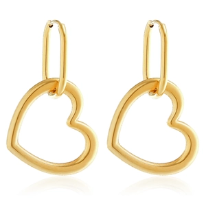 Close-up of golden hollow heart drop earrings with oval hoops on a reflective surface