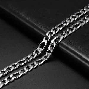 Macro shot of silver stainless steel Cuban link necklace on a dark leather texture background