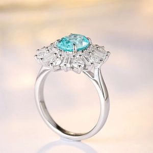 Macro shot of silver ring with oval sea-blue center stone and halo of clear gems