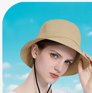 Close-up of beige outdoor sun hat with black chin strap against a blue sky background