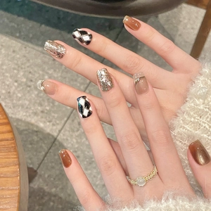 Brown checkerboard press-on nails with amber cat-eye and champagne glitter finish