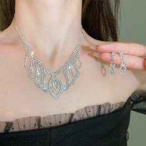 Close-up of sparkling silver fringe necklace and matching earrings with rhinestones