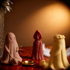Halloween candle set featuring ghost and skull reaper figures on a dark wooden surface