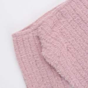 Gros plan sur un tricot en maille pelucheuse rose montrant la texture et les côtes