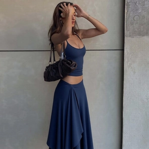 Detail of navy blue two-piece set featuring halter crop top and irregular hem maxi skirt