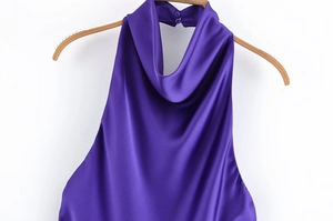 Detailansicht des dunkelvioletten Neckholder-Tops aus Satin auf einem Holzbügel vor weißem Grund