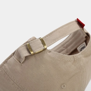 Beige cotton baseball cap featuring adjustable bronze metal buckle and premium stitching detail