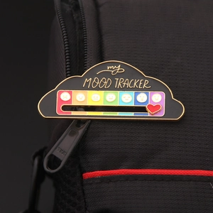 Detail of sliding heart tracker on black cloud mood pin with rainbow scale and emoji symbols