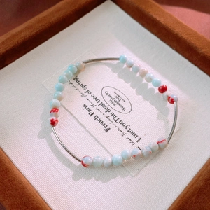 Detailed shot of aquamarine beaded bracelet with silver tubes in a luxury jewelry box