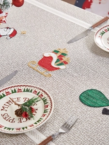Detailed embroidery of Santa sleigh and trees on festive beige linen Christmas tablecloth