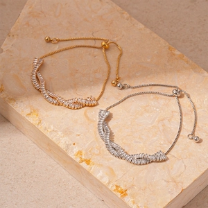 Elegantes verstellbares Zirkon-Armband-Set in Gold und Silber auf Marmoroberfläche