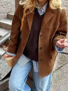Détail d'une veste en daim marron foncé avec revers classique et fermeture à boutons vintage