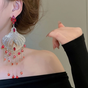 Macro detail of vintage silver needle drop earrings with long crystal tassels on model