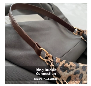 Detailaufnahme der Leoparden-Handtasche mit goldenem Ringverschluss und Lederriemen
