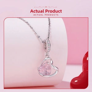 Macro detail of S925 silver heart charm with pink crystal and tree of life engraving